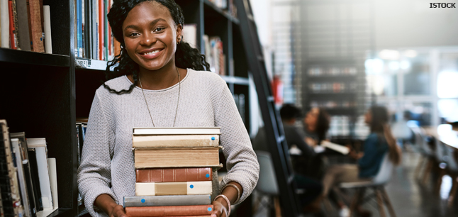  Librarian returning books to shelves in the library