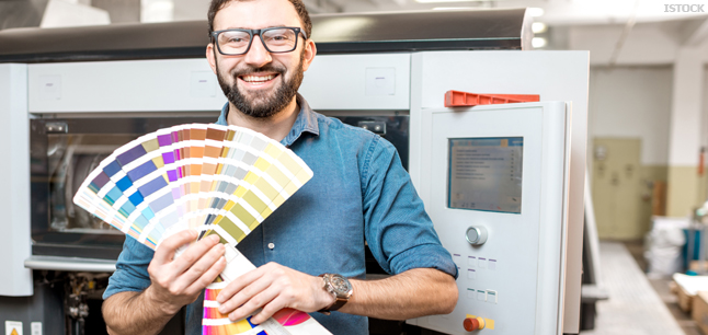 Printer with ink swatch book in front of printing press