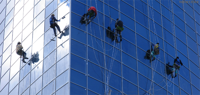 Workers washing windows of tall office building