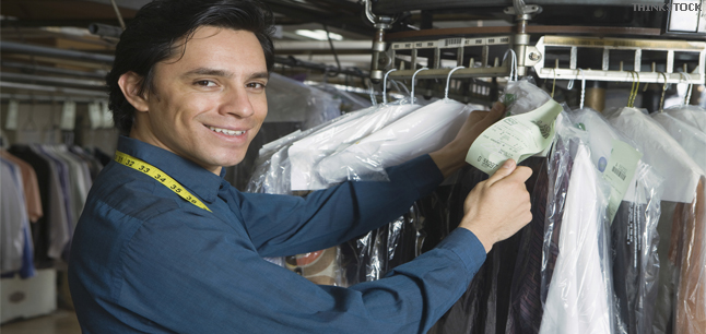 Young male laundrette owner sorting through clothes