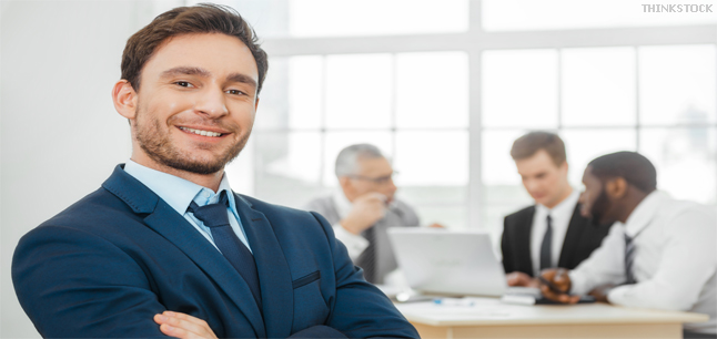 Businessman and his colleagues using laptop in background