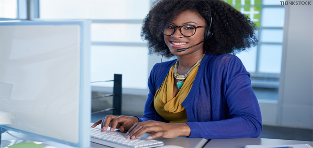 Call center employee working at a computer in a modern white office
