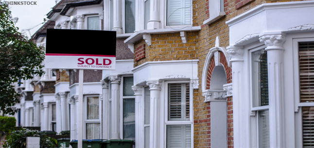 A sold sign posted outside a terraced house