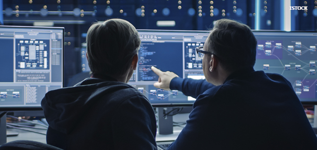 Two blockchain developers examining code on a computer screen